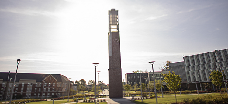 sun shines behind Deese Clock Tower