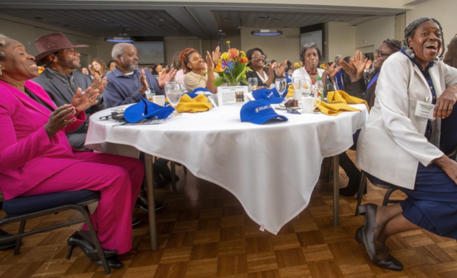 Individuals sitting at a table laughing and enjoying themselves over good food and companionship