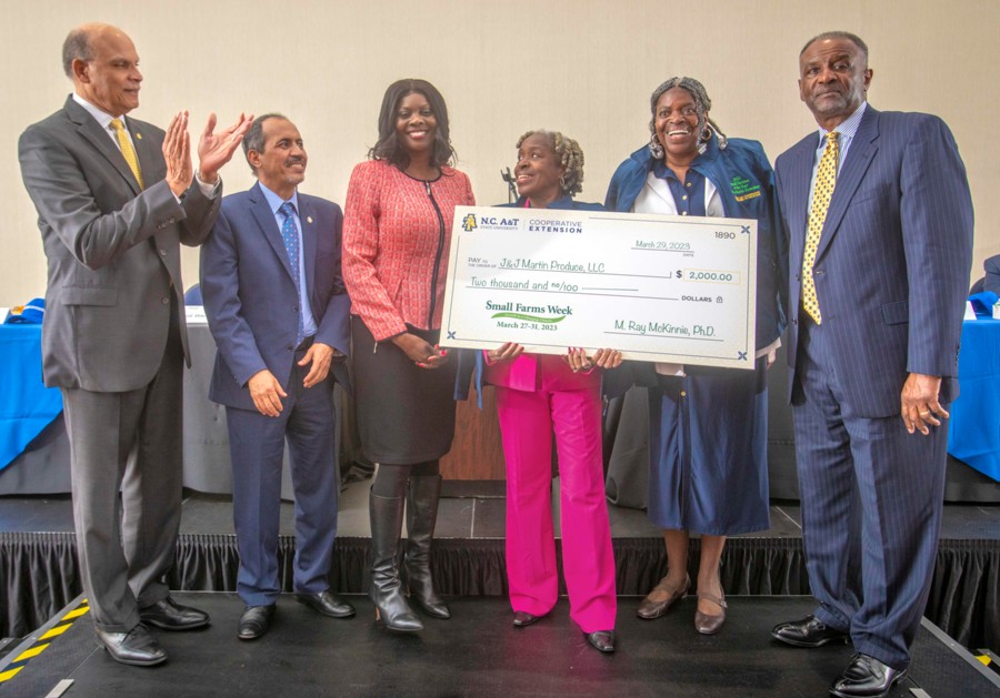 Small farmer of the year, 2023, winner holding their check with the chancellor to the side clapping