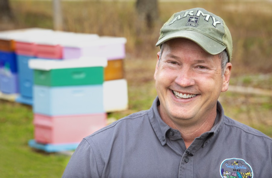 James Hartman, standing in front of his bee houses.