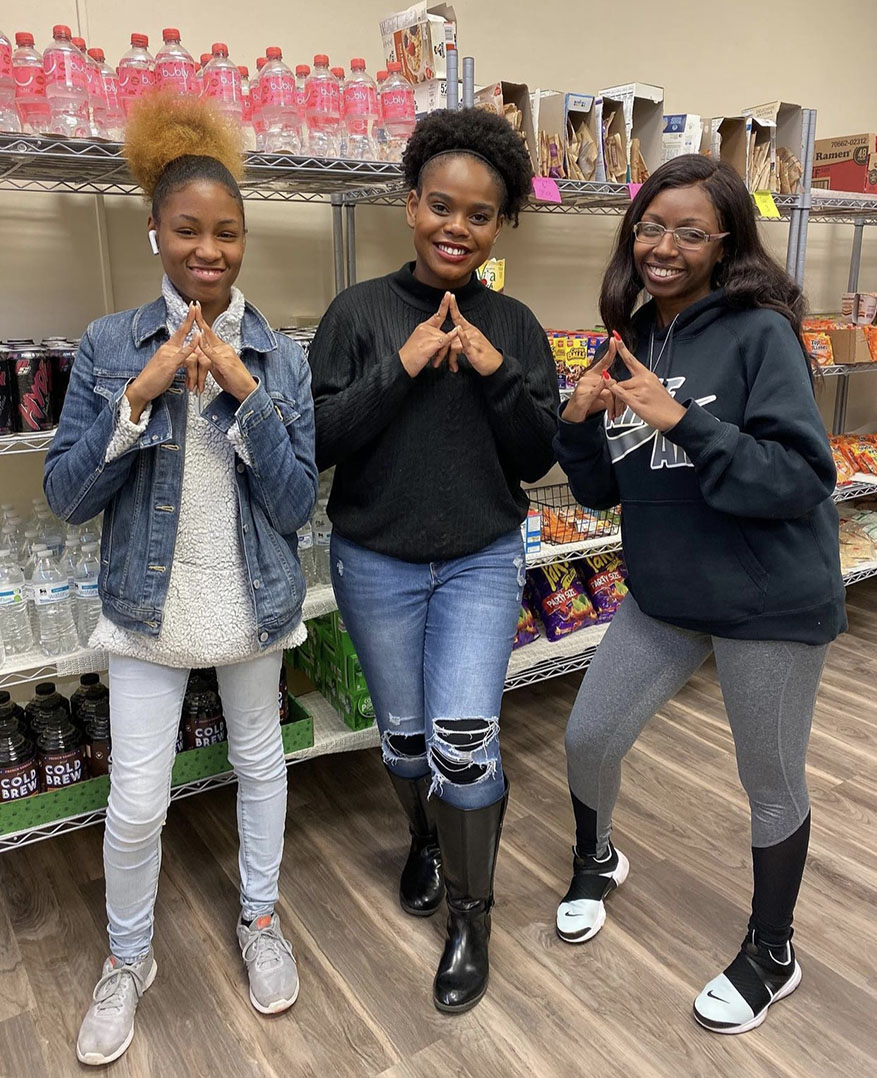 Three students standing in the food pantry