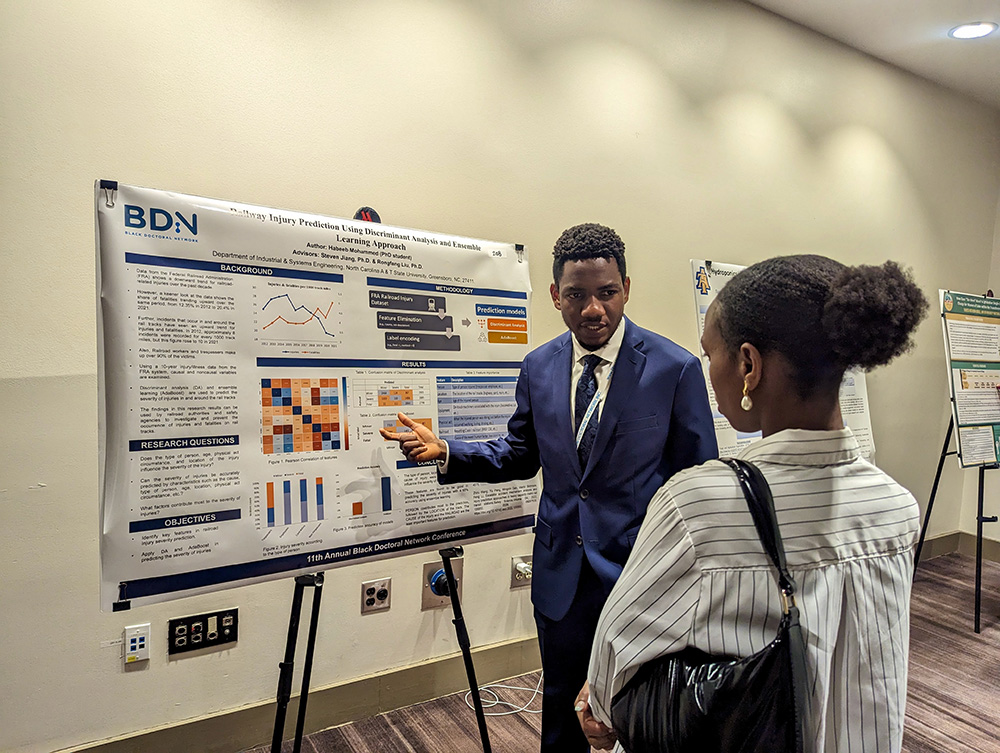 Habeeb interacting with a poster session attendee at the conference.