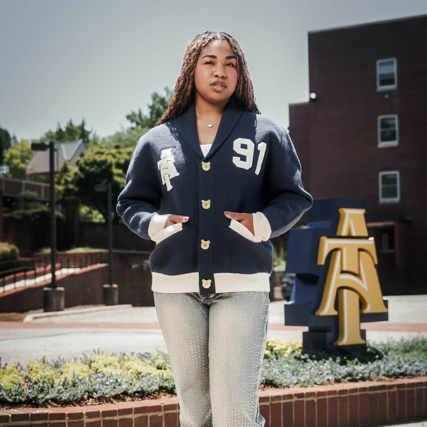 Woman wearing N.C. A&T Cardigan with tan and navy blue colors
