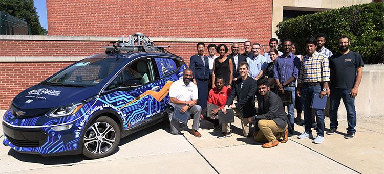The group picture outside by the autonomous car