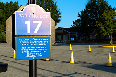 Lot 17 parking sign with the striped lot and traffic cones in the background